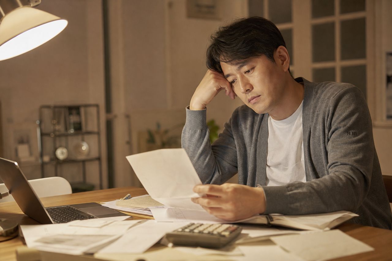 회사 재직 중 채권자 압류 통보 받은 35세 직장인 — 개인회생절차 개시신청 후 급여 보전까지, 2026.2.12 행정정보 공동이용 개정으로 서류 준비가 달라진 것 3가지 관련 상황을 보여주는 이미지 — 서류를 검토하는 모습
