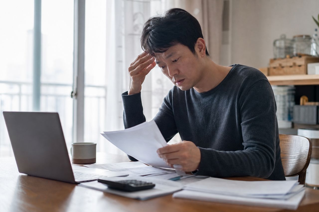 학자금대출 + 카드빚 2,800만 원, 취업 첫해 연체 시작 — 개인회생 신청하면 취업 사실이 법원·채권자에게 노출되는 경로와 공공기록이 회사 인사팀에 보이는지 여부 관련 상황을 보여주는 이미지 — 서류를 검토하는 모습