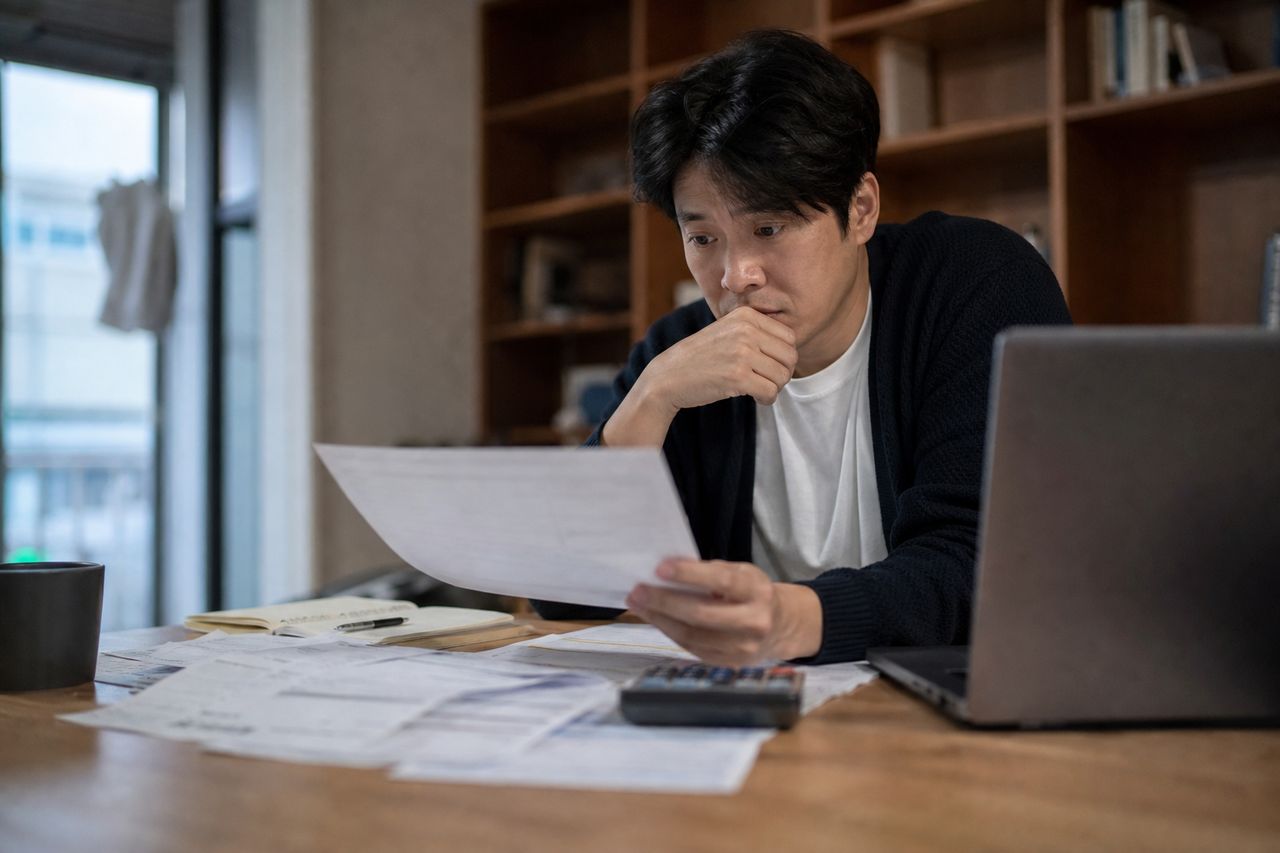 회사 다니면서 주식 레버리지 투자 손실 1억 2,000만 원 — '개인회생 파산 차이 어떤게 유리한지 상담' 할 때, 새 직장 소득 변동이 변제금에 미치는 영향 관련 상황을 보여주는 이미지 — 서류를 검토하는 모습