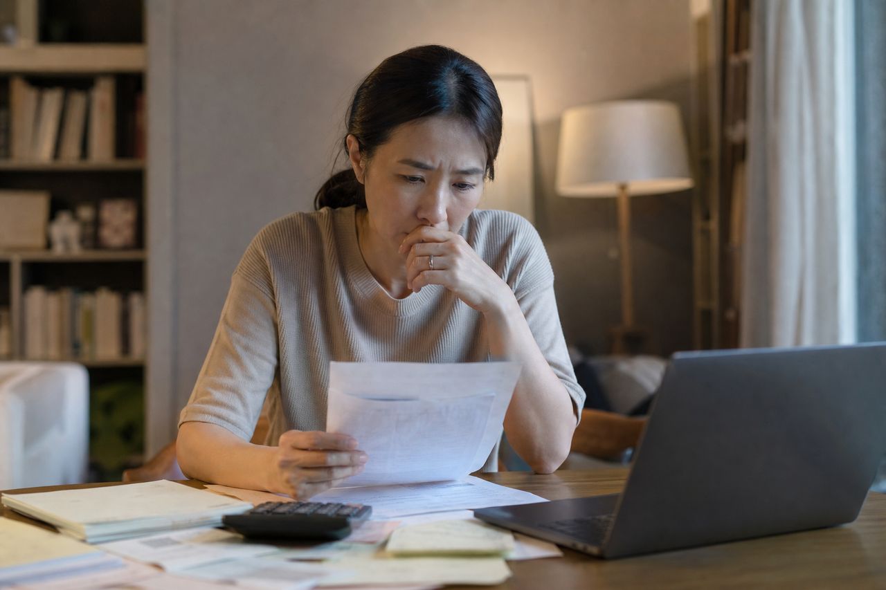 성과급 포함 연봉 5,500만 원인데 월 실수령은 330만 원 — 개인회생신청자격조회 시 법원이 '연봉/12'와 '실수령액 중 어떤 걸 소득으로 보는지', 이직 협의 중 소득 변동이 변제금 산정을 바꾸는 타이밍과 인가결정 전후 차이 관련 상황을 보여주는 이미지 — 서류를 검토하는 모습
